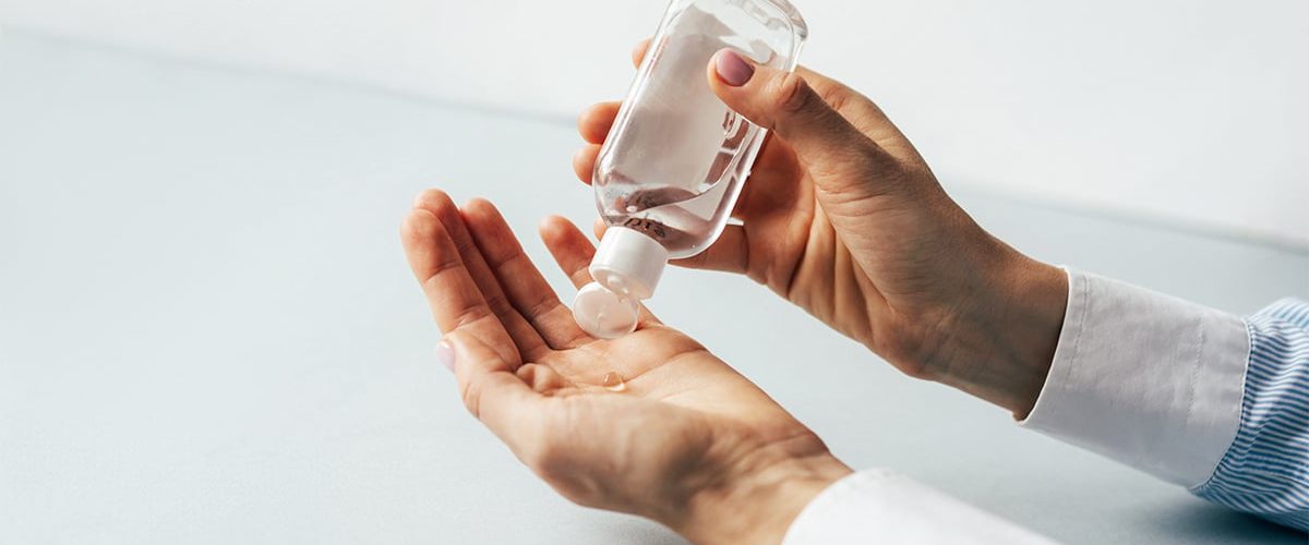 Businessman using commercial hand sanitizer in the workplace