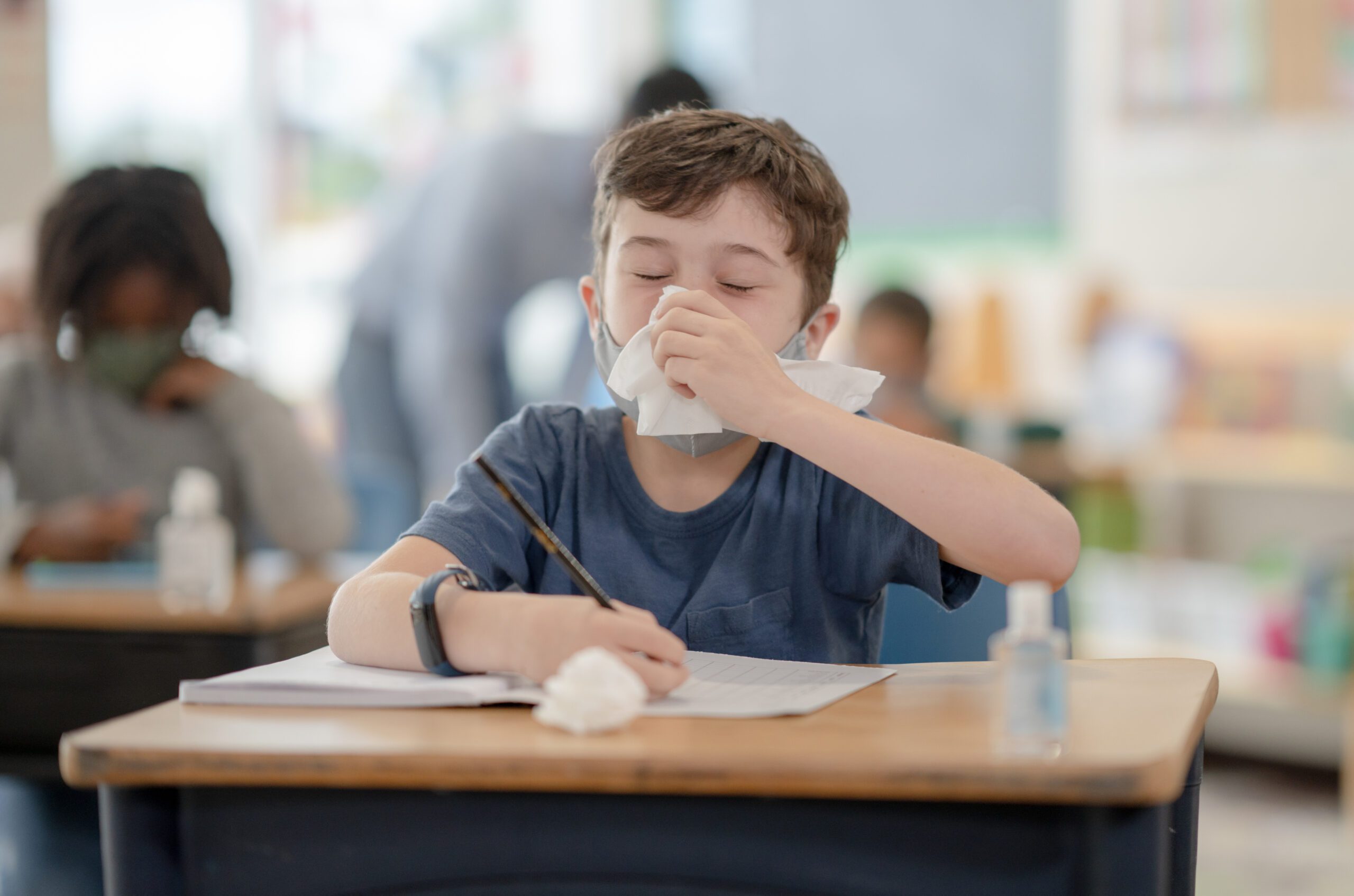 Children coughing and blowing their nose in the classroom.